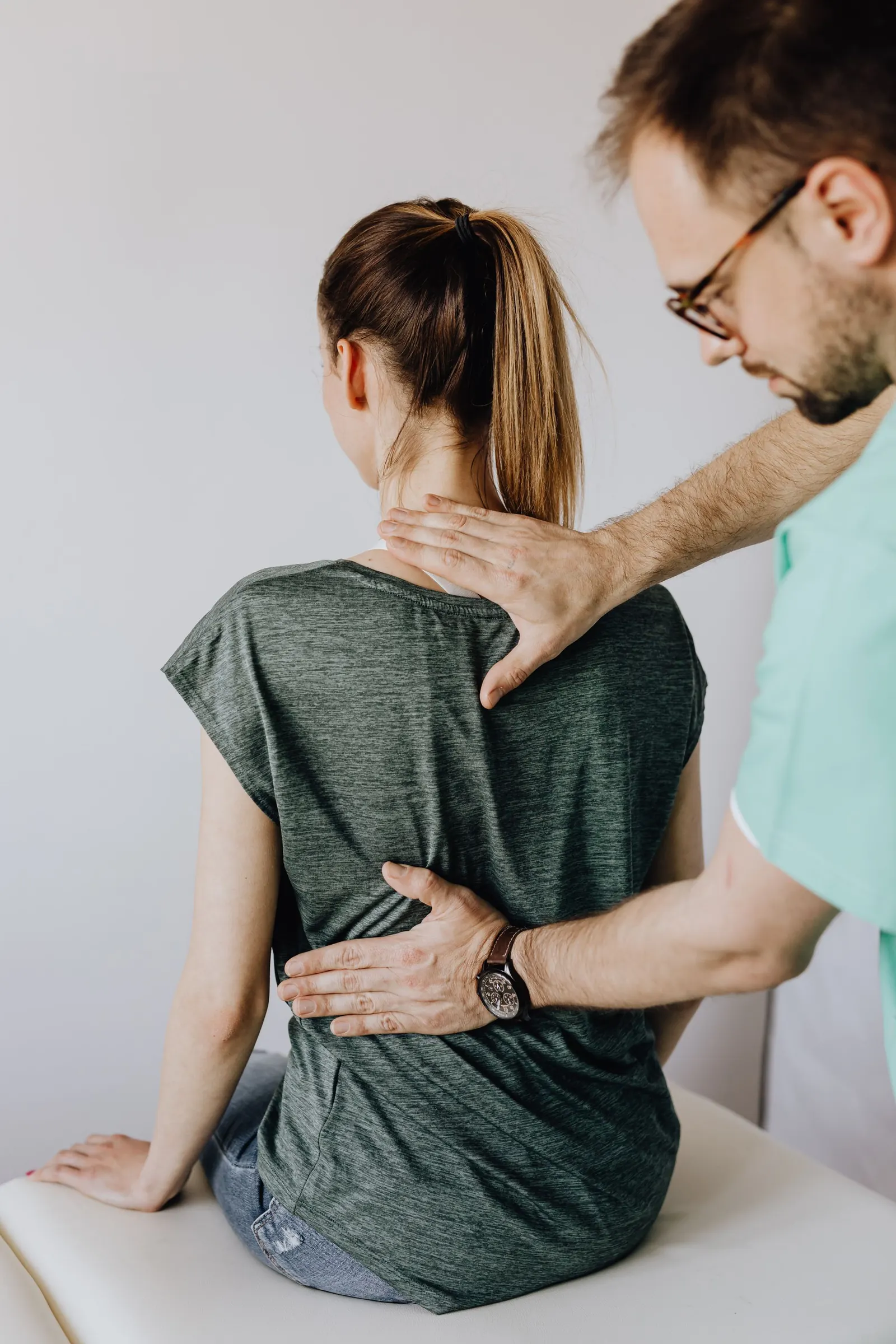 Clinician assessing a patient's spine and posture